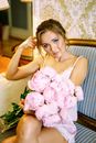 Woman in White Nightgown Holding up Bouquet of Pink Roses