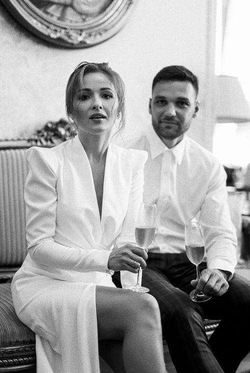 Free Sophisticated black and white photo of an elegant couple seated with wine glasses indoors. Stock Photo