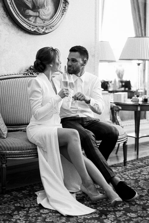 Free Chic black and white image of a couple toasting champagne indoors, exuding elegance and sophistication. Stock Photo