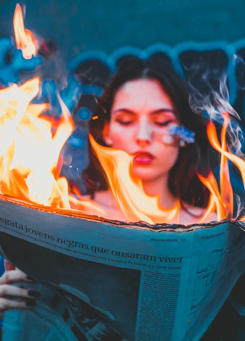 Woman Holding Burning Newspapers