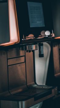 A sleek smart coffee maker on a kitchen counter showing an app-controlled coffee brewing interface.