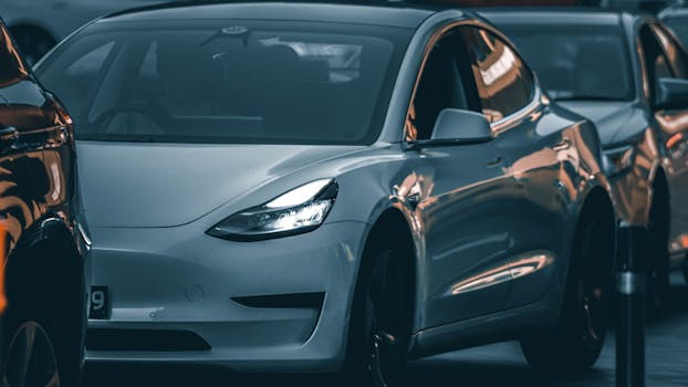 A sleek modern car reflecting city lights during a traffic jam at dusk, showcasing urban transportation.