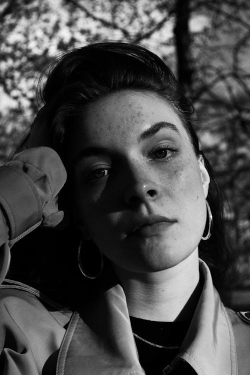 A Grayscale Photo of a Woman with Freckles on Her Face