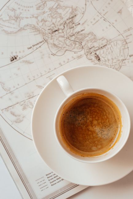 Aerial view of coffee cup placed on a nautical map, conveying exploration and adventure