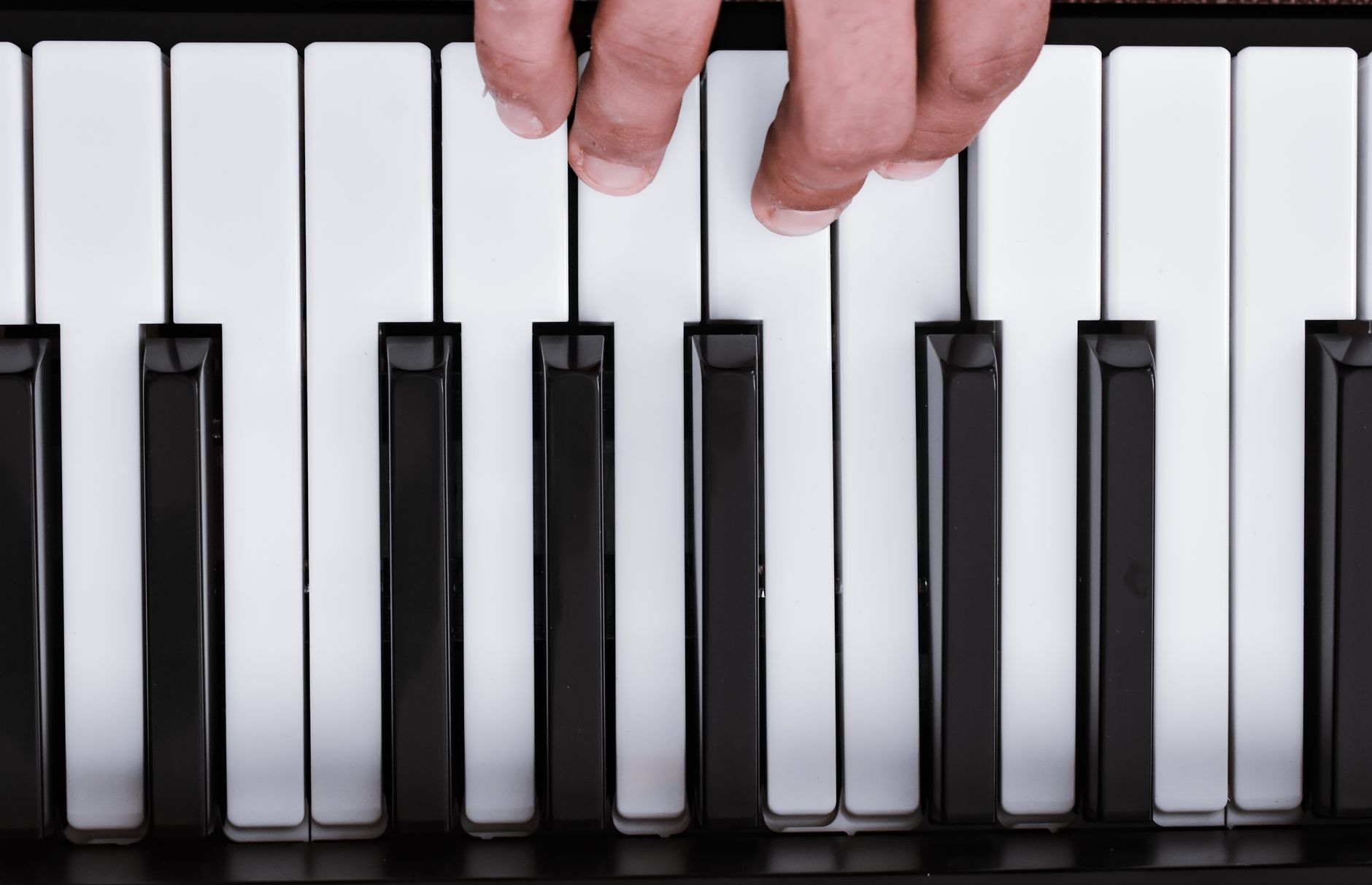 A detailed view of a hand playing piano keys, capturing the essence of musical expression.