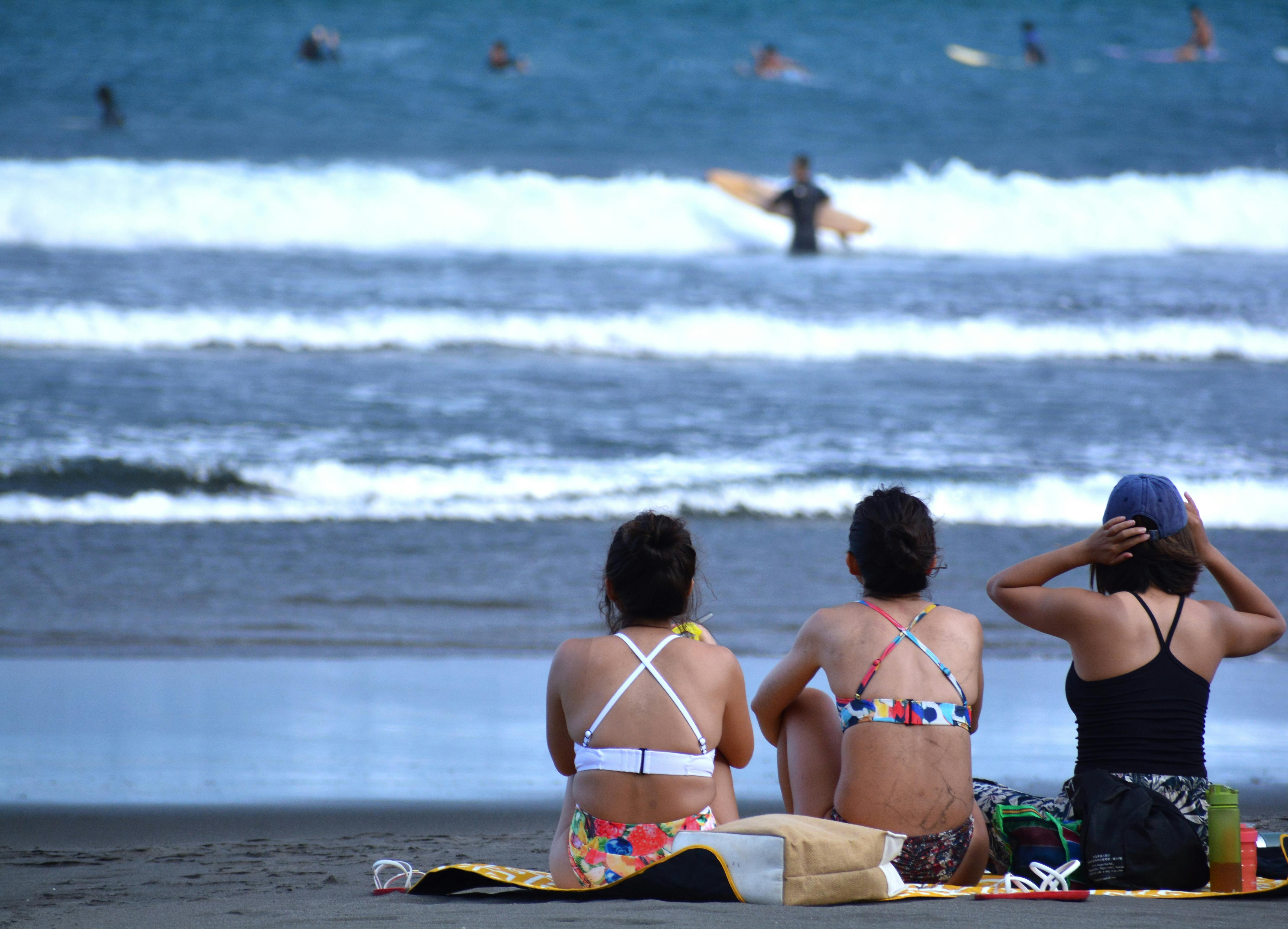 women sitting on the beach