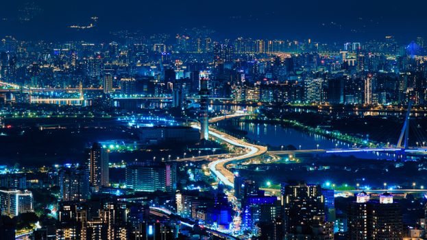 A dynamic night view of a modern city with dazzling lights and urban architecture.