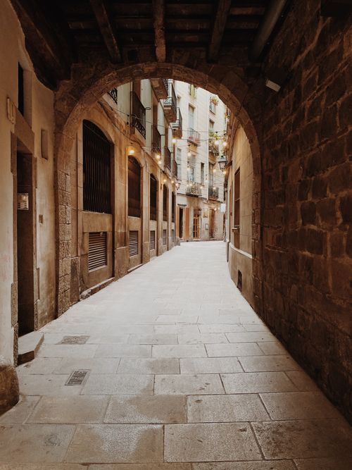 Free Explore a picturesque, narrow alleyway with beautiful stone architecture and warm lighting. Stock Photo