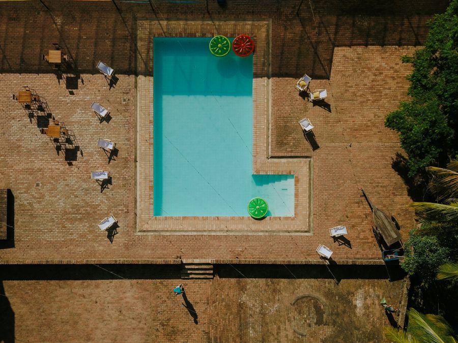 Área da piscina adulto com espreguiçadeiras e vegetação