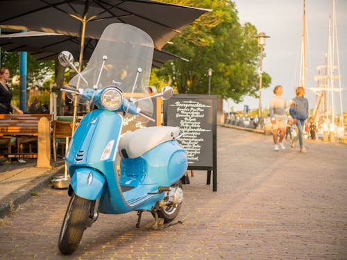 A Blue Vespa with Windshield