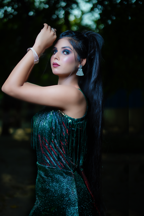 Free Stunning portrait of a woman in a green dress posing outdoors, capturing elegance and fashion. Stock Photo