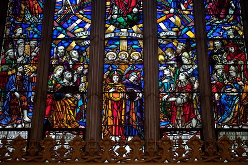 Free Detailed view of a colorful stained glass window depicting religious figures in a gothic cathedral setting. Stock Photo