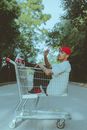 Man in Brown Shirt and Red Cap Holding Shopping Cart