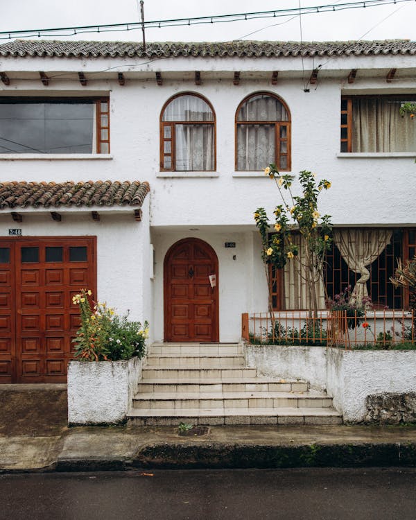 Brown Wooden Door on White Concrete House