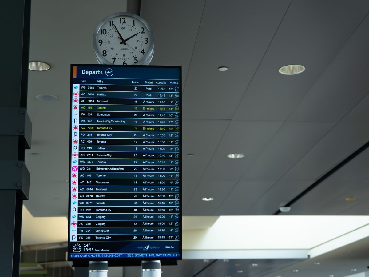 Airport departures board showing a list of flight times and destinations