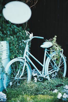 郁郁葱葱的树叶和鲜花环绕着一辆蓝色老式自行车，营造出异想天开的花园场景