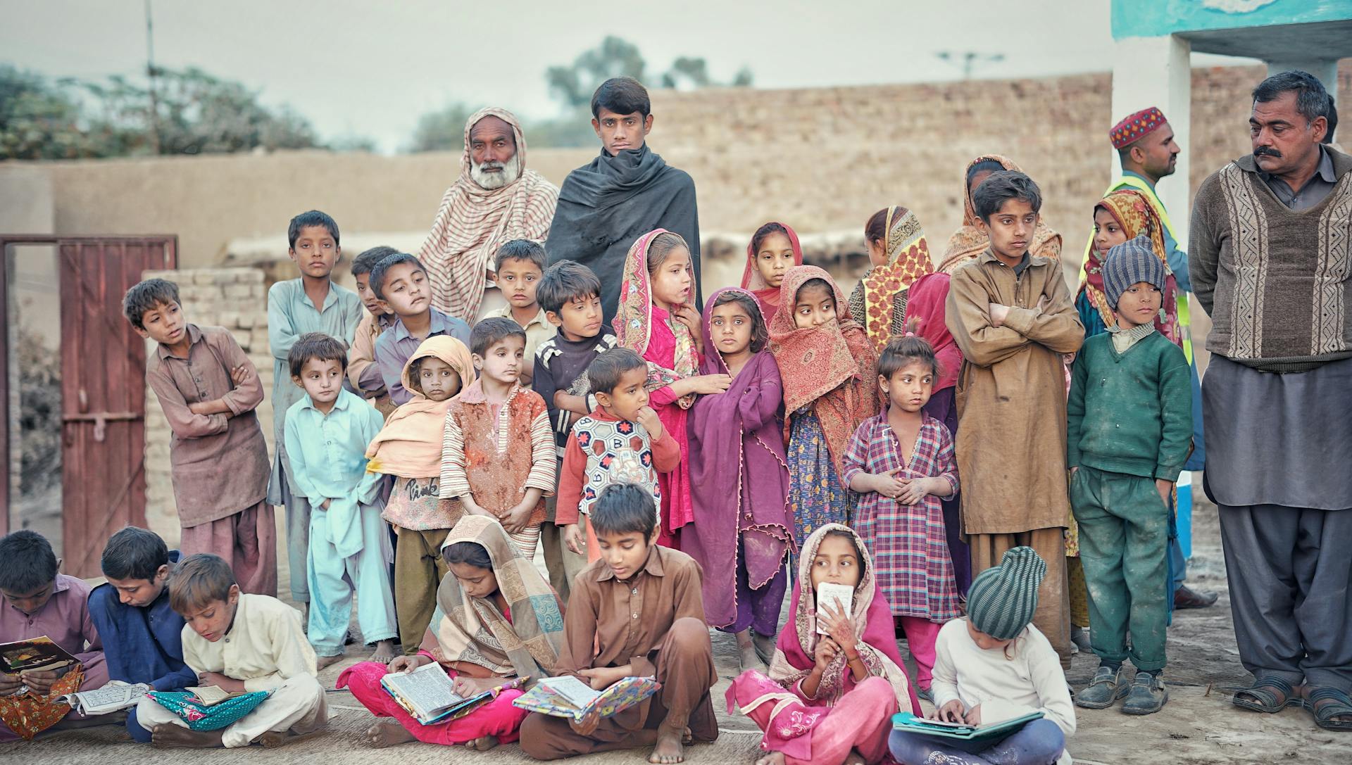 A diverse group of children and adults engaged in outdoor education in Pakistan.