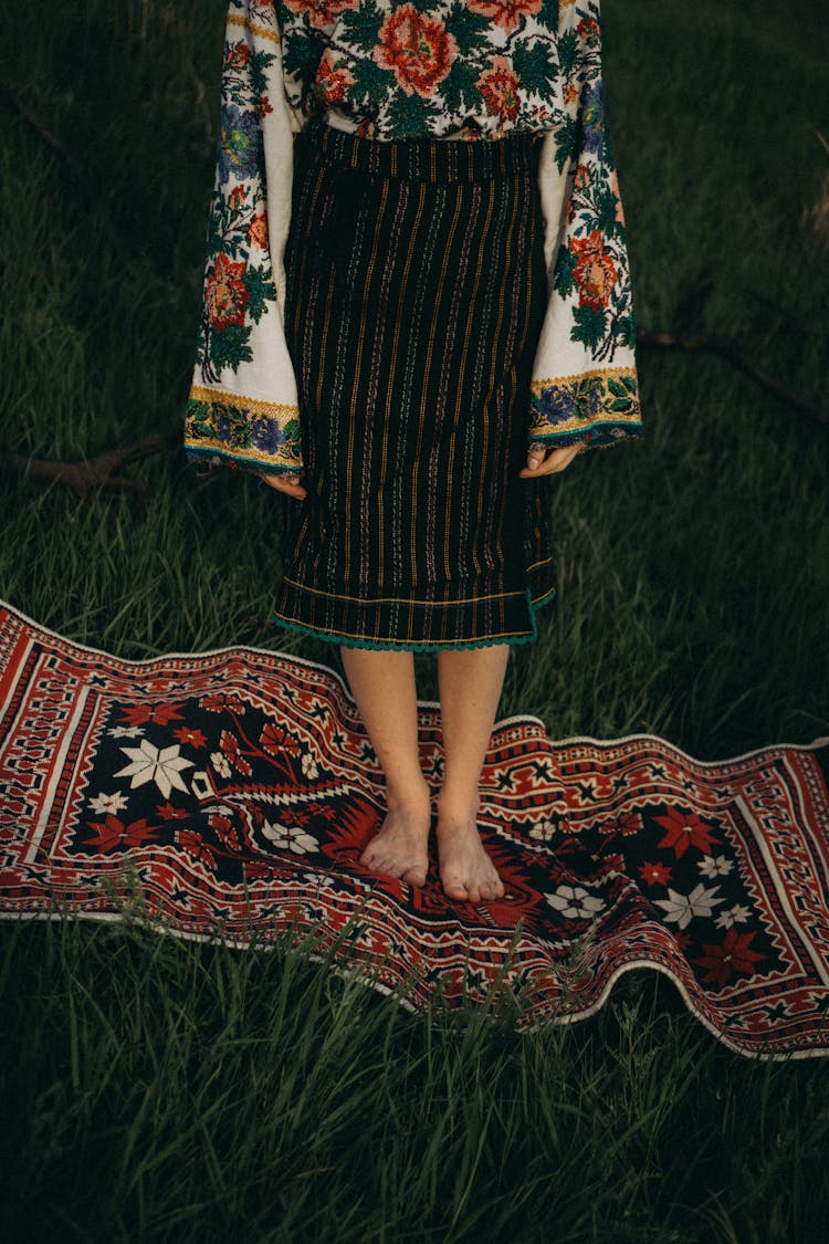 Woman In A Skirt Standing On A Rug On The Grass