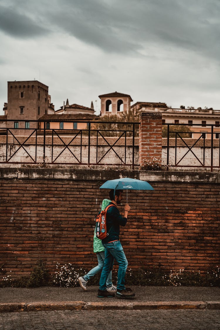 Person Walking Down The Street Holding An Umbrella