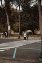 Couples are walking on street with yellow umbrella at rainy day