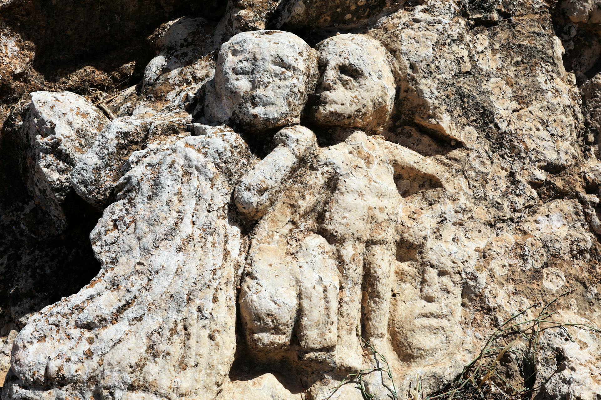 Weathered bas relief carving on a Libyan rock face, showcasing ancient artistry.