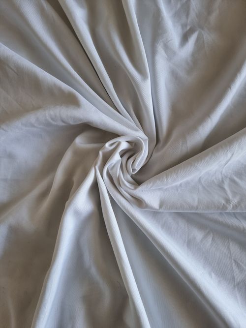 Free High-quality image of white cotton fabric with a swirling pattern. Ideal for textile and interior design concepts. Stock Photo