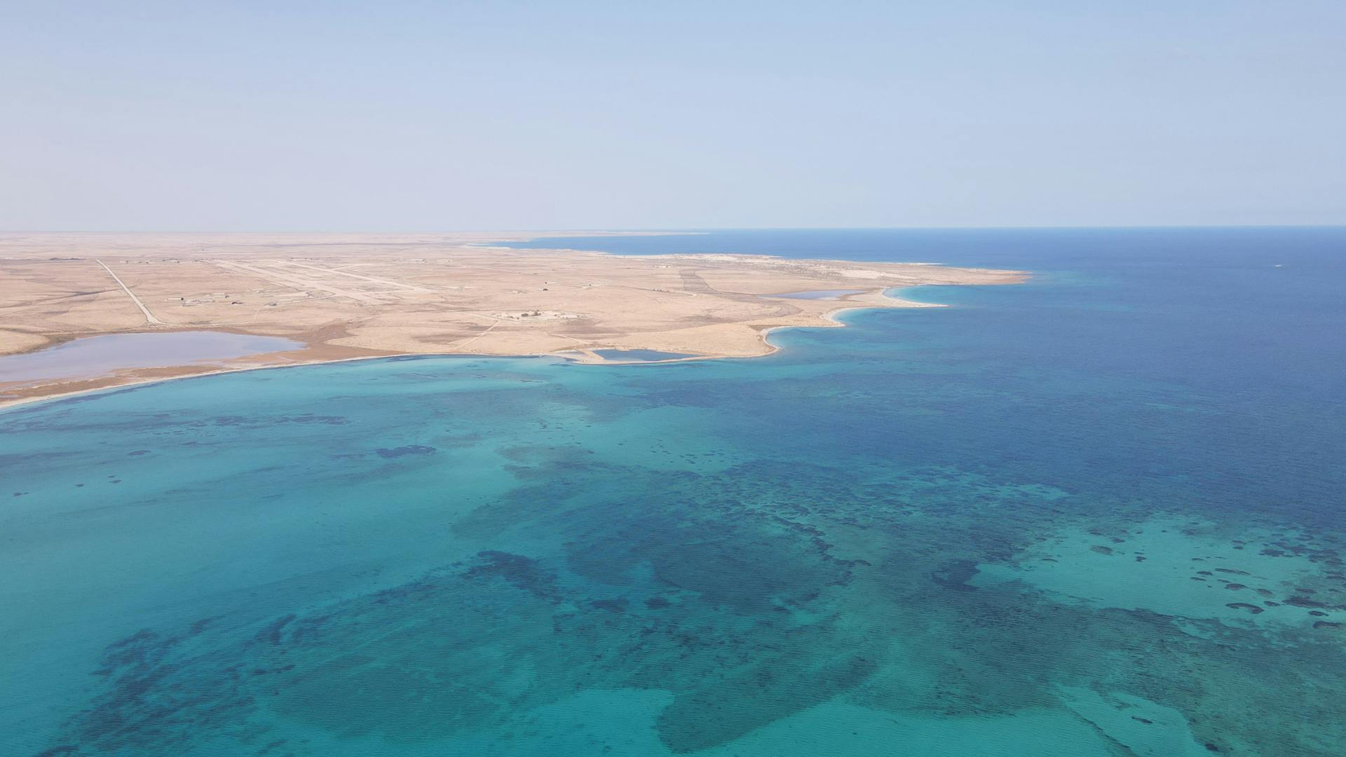 Beautiful aerial view of the azure Libyan coastline at Bombah, showcasing vibrant blue waters and sandy shores.