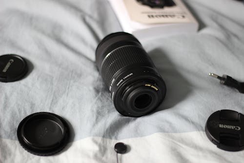 Camera Lens and Lens Caps on the Bed