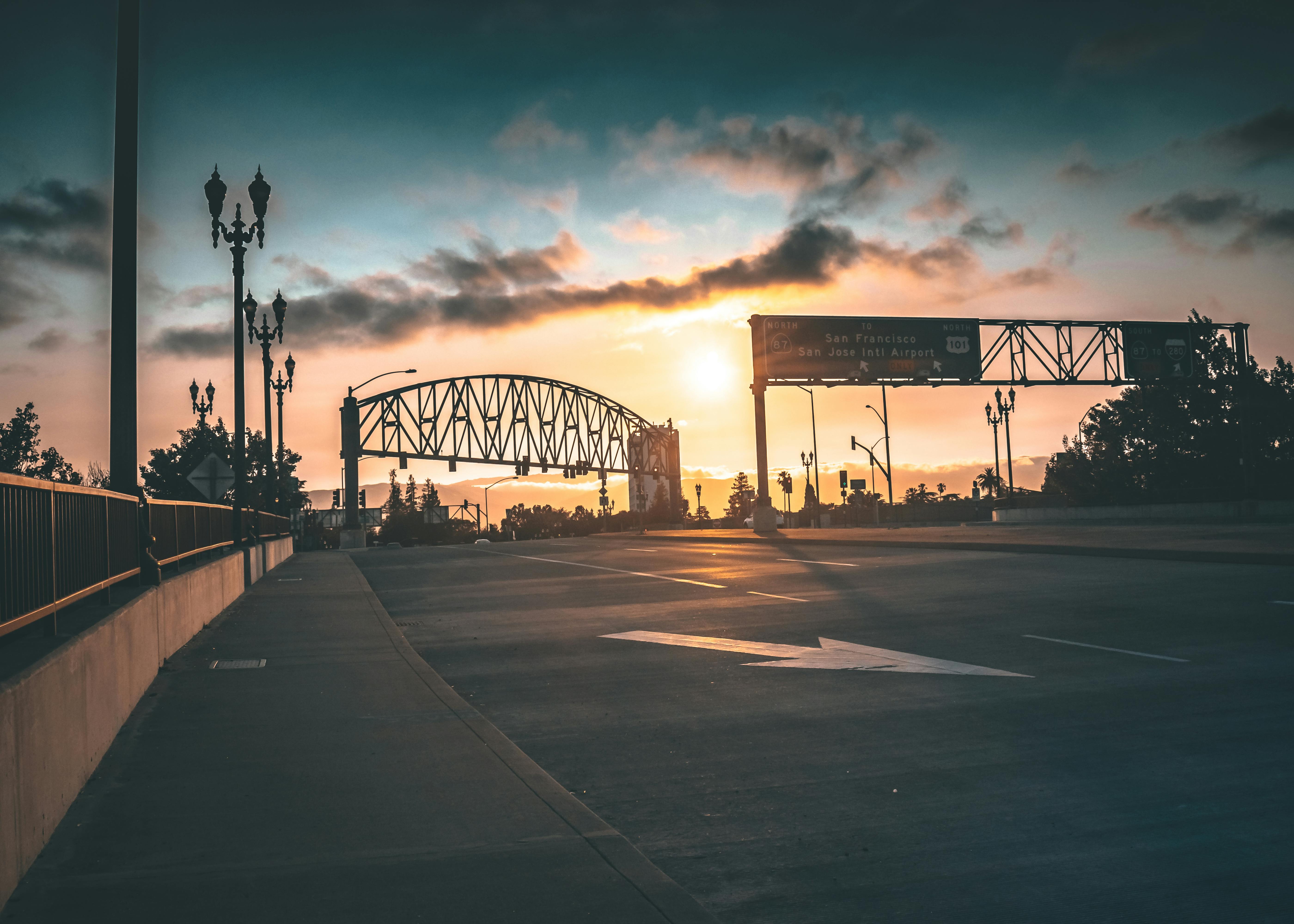 日落映衬着城市景观中的桥梁和路牌，充满活力