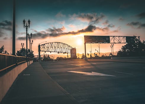 日落映衬着城市景观中的桥梁和路牌，充满活力