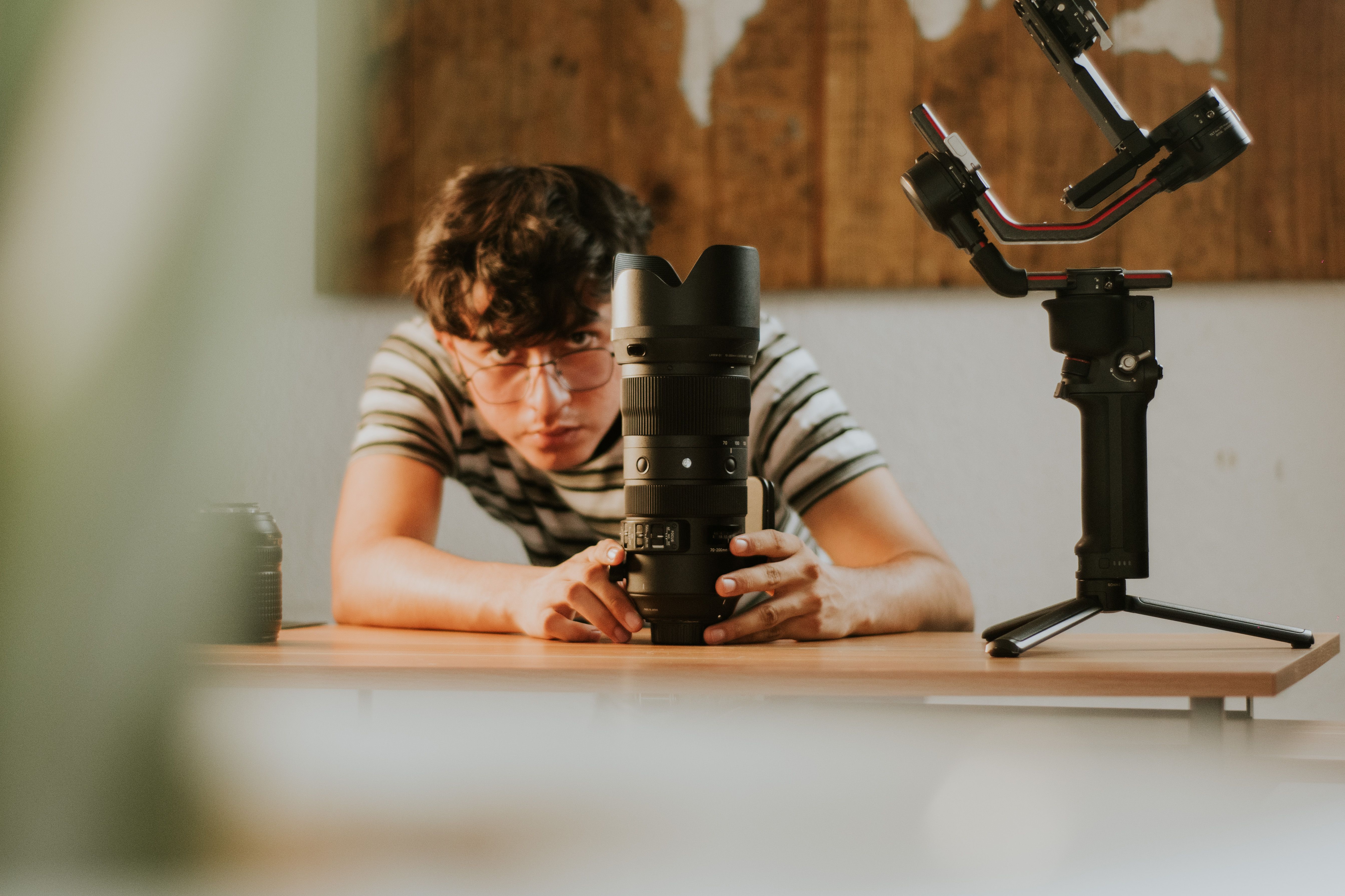 photographer adjusting a camera on a tripod beside a styled ceramics table