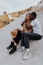 Man in White Crew Neck T-shirt and Woman in Black Tank Top Sitting on White