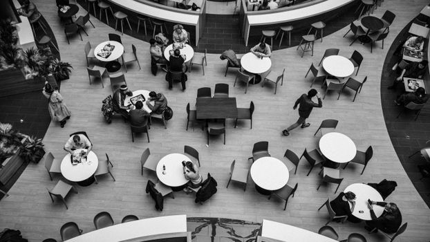 Black and white shot of people in a stylish, indoor coffee shop in Moscow.