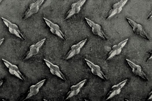 Detailed image of a textured metal tread plate with a repetitive pattern.