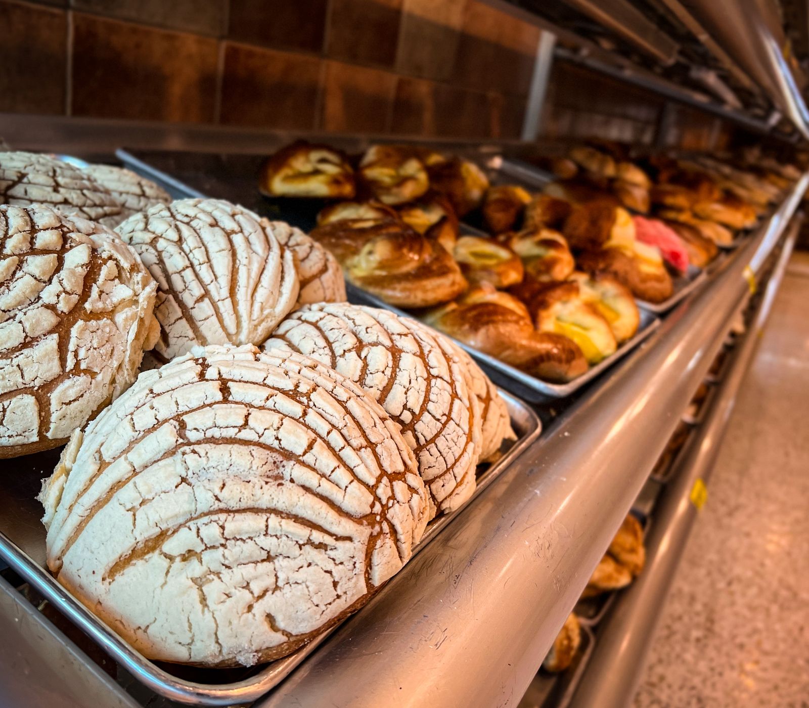 Fresh Latin bakery bread and pan dulce on a bakery shelf