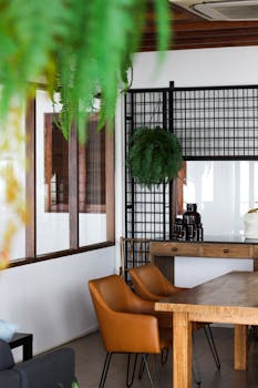 Stylish cafe interior in Thailand with wooden furniture and hanging plants.