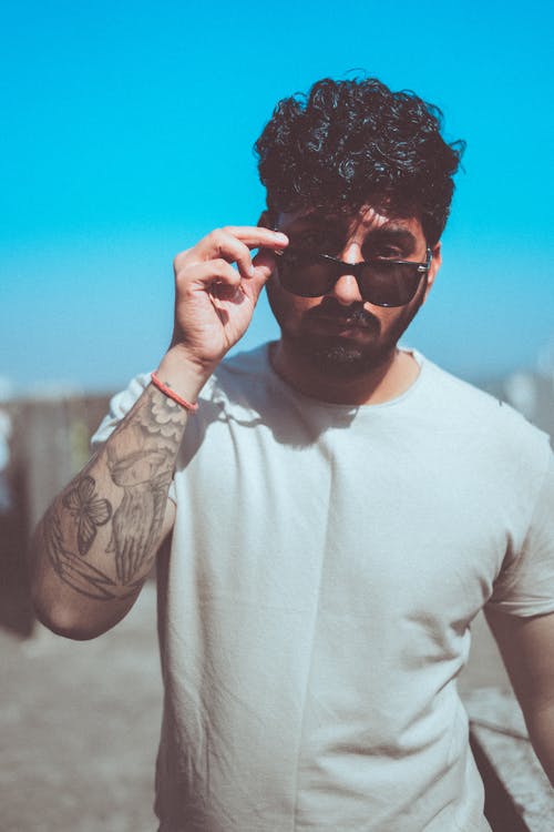 Man with a Beard Holding Sunglasses