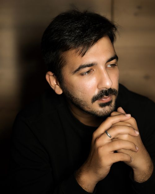 Free A thoughtful man with facial hair, hands clasped, wearing a ring, captured indoors. Stock Photo