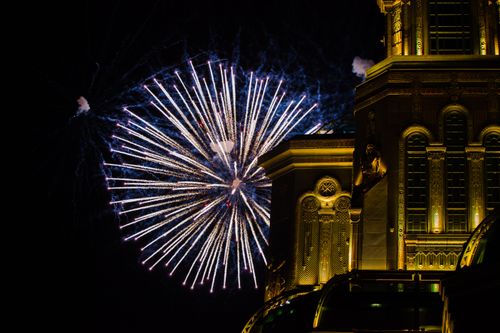 Free Festive fireworks illuminate a beautifully ornate building against the night sky, creating a striking scenic view. Stock Photo