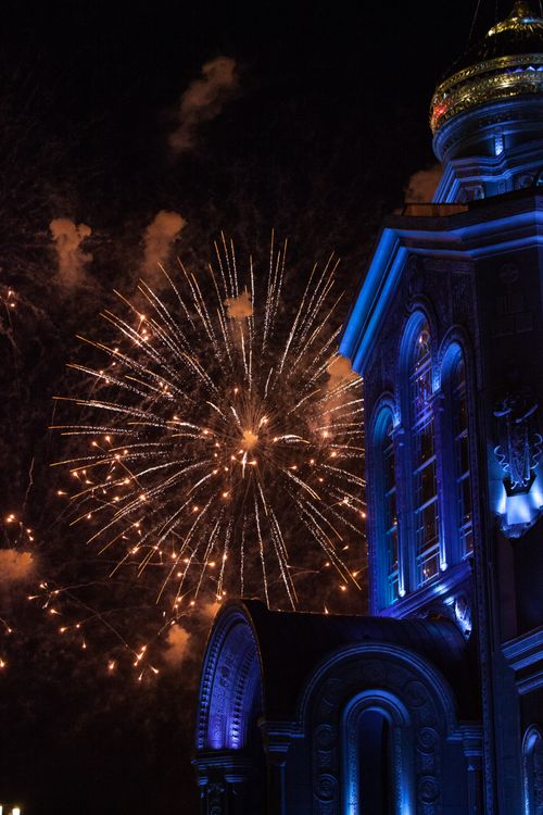 Free Vibrant fireworks light up the night sky over a beautifully illuminated cathedral. Stock Photo