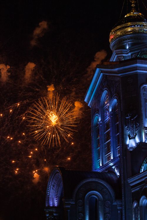 Free A captivating display of fireworks light up the night sky over an illuminated cathedral. Stock Photo
