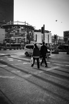 Black and white street scene in Turkey with pedestrians and Turkish flag.