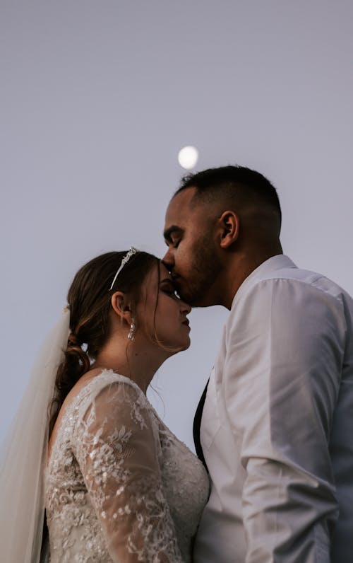 A Man Kissing a Bride on Her Forehead 