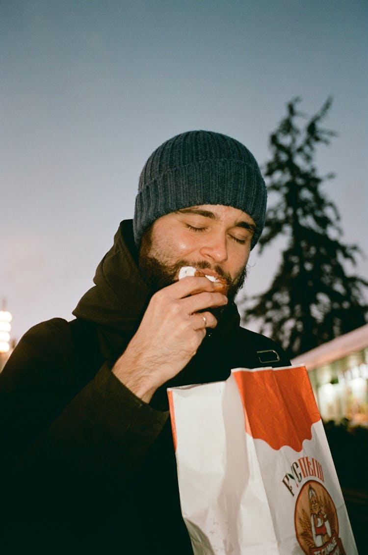 Man Wearing A Beanie Eating Donut