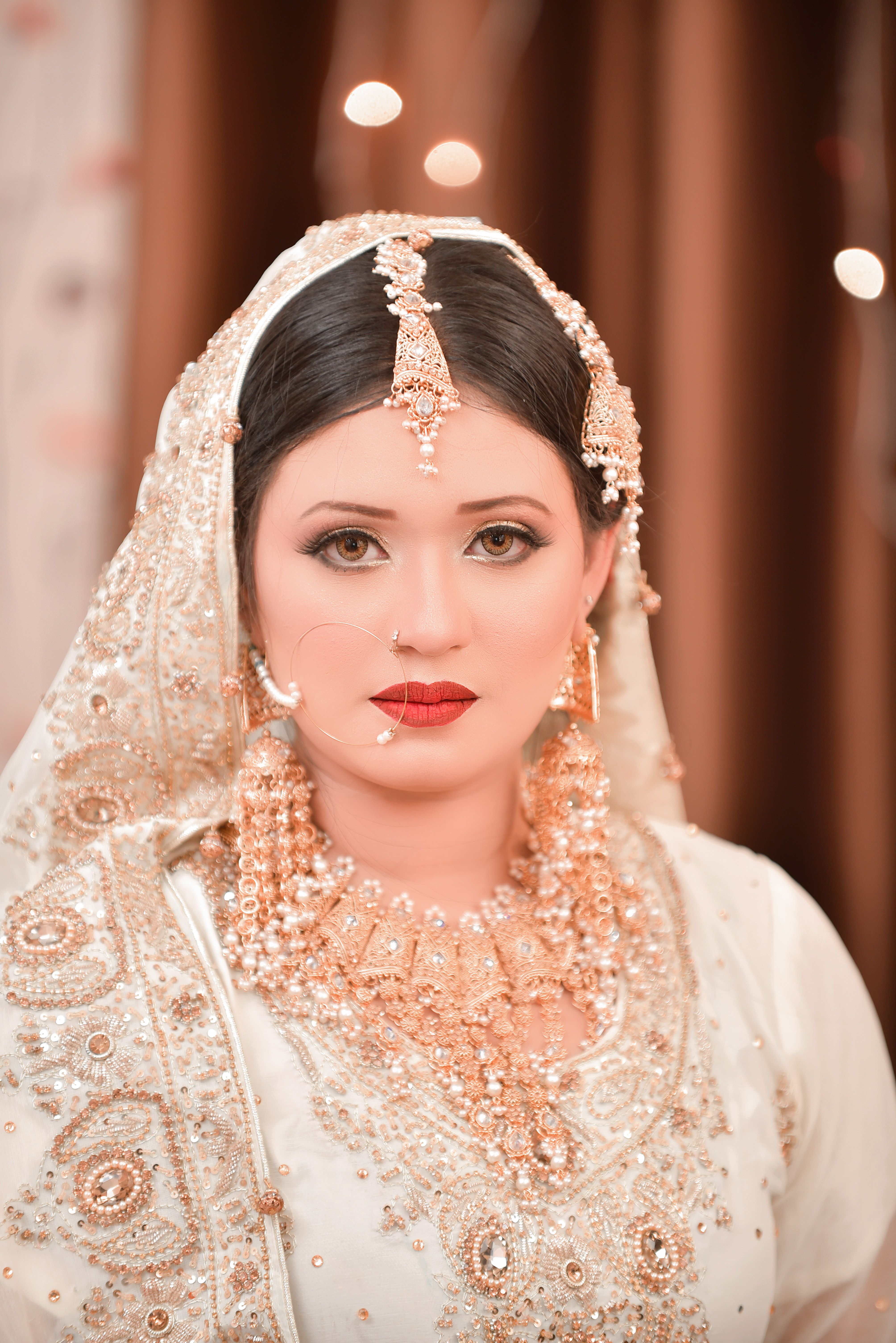 Beautiful South Asian bride in ornate traditional wedding dress and jewelry.