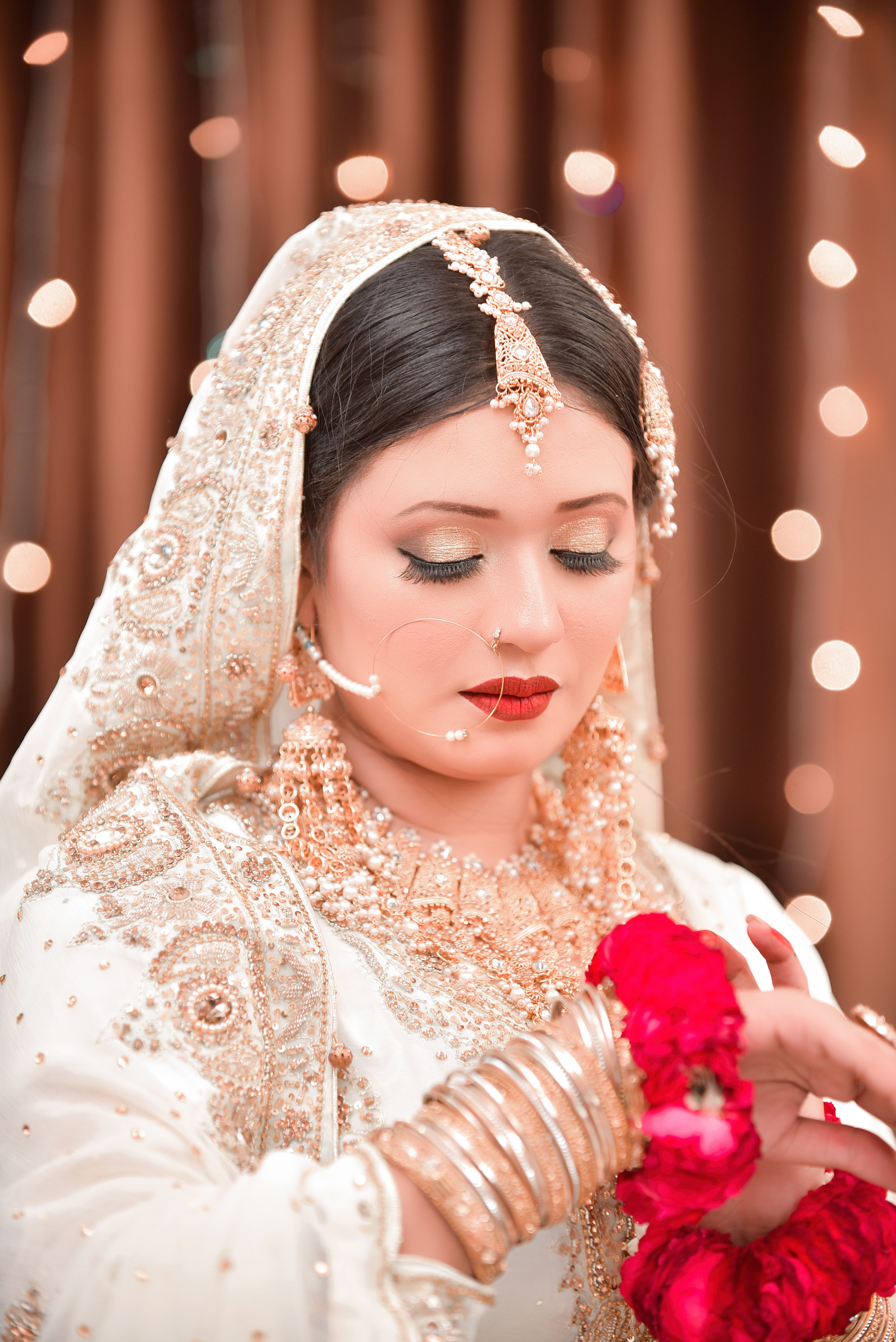 Close-up portrait of a bride in traditional attire with intricate jewelry and a delicate veil.