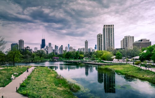 бесплатная Река возле городских зданий под пасмурным небом Стоковое фото