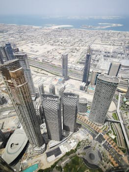 Stunning aerial view of high-rise buildings in Dubai, with coastal scenery in the background.
