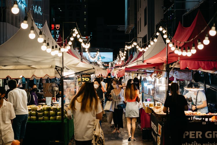 People Shopping At A Street Market At Night