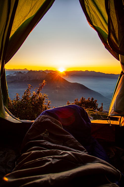 Watching Sunrise from Tent in Mountains